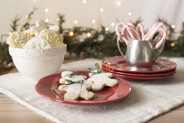 Nahaufnahme von Lebkuchen Kekse mit Weihnachtsschmuck auf dem Tisch gegen beleuchtete Lichter - CAVF49313