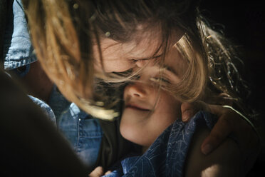 Close-up of mid adult mother embracing smiling daughter - CAVF49335