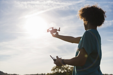 Boy flying a drone outdoors stock photo
