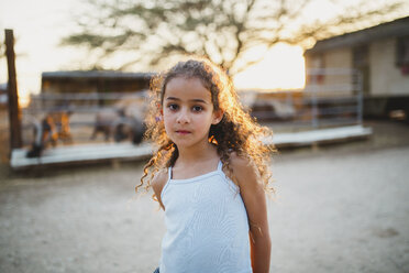 Porträt eines Mädchens auf einem Bauernhof bei Sonnenuntergang - CAVF49365