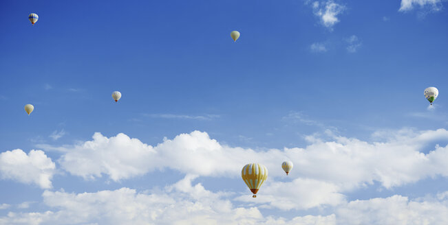 Heißluftballons fliegen in bewölktem Himmel - CAVF49519