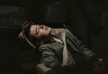 Boy with eyes closed sitting in car - CAVF49536