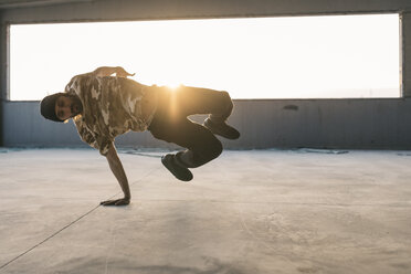 Mann tanzt Breakdance in städtischem Betongebäude, auf der Hand stehend - JRFF01910