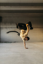 Mann tanzt Breakdance in städtischem Betongebäude, auf der Hand stehend - JRFF01911