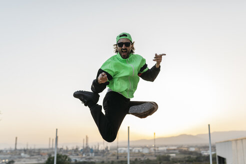 Man doing breakdance in urban concrete building, jumping mid air - JRFF01913