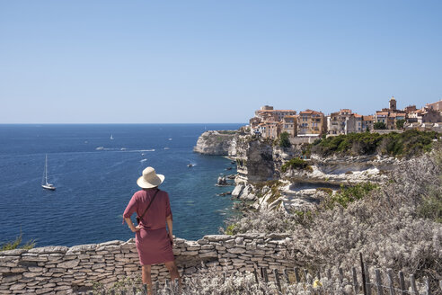 Korsika, Bonifacio, Frau steht auf einem Aussichtspunkt und blickt auf die Stadt - HAMF00468