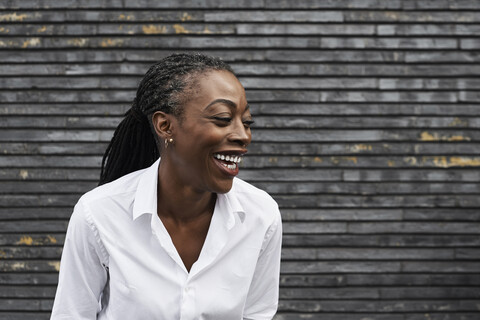 Portrait of laughing businesswoman wearing white shirt stock photo