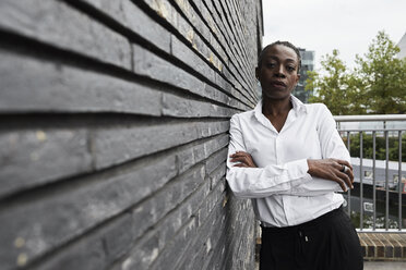 Portrait of serious businesswoman leaning against wall - IGGF00673