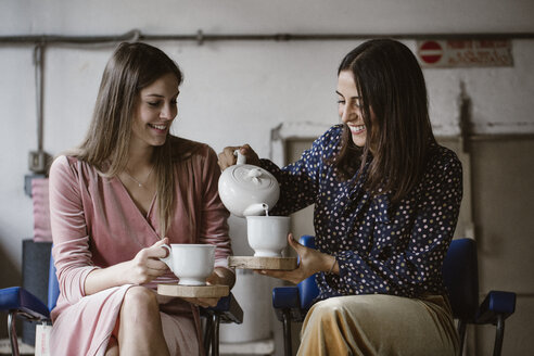 Two friends drinking tea together in a loft - ALBF00645