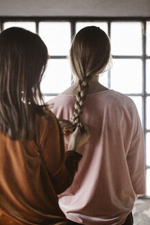 Rückenansicht einer jungen Frau, die das Haar ihrer Freundin flechtet - ALBF00657