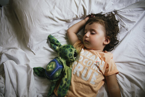 Baby girl sleeping on bed with t-shirt message 'Dreams do come true' - GEMF02423