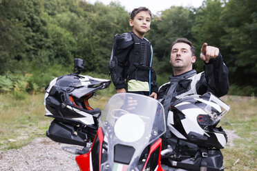 Vater und Sohn machen eine Pause während einer Motorradtour - FBAF00133