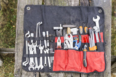 Sortiment von Werkzeugen auf Holztisch im Freien - FBAF00136