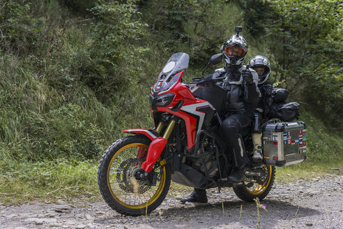 Vater und Sohn machen eine Pause während einer Motorradtour - FBAF00138