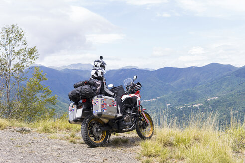 Italien, Toskana, Pistoia, Vater und Sohn machen eine Pause am Aussichtspunkt während einer Motorradtour - FBAF00139