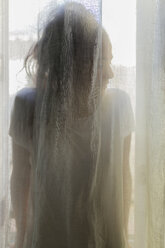 Silhouette einer jungen Frau hinter einem Vorhang - JPTF00026