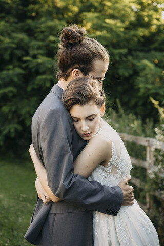 Bride and groom embracing outdoors stock photo