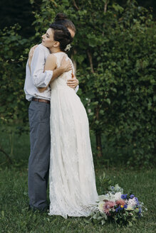 Braut und Bräutigam stehen sich umarmend auf einer Wiese - ALBF00691