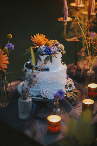 Hochzeitstorte auf Tisch mit Kerzen im Freien, lizenzfreies Stockfoto