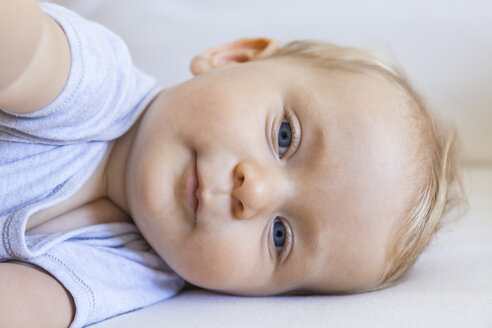 Portrait of blond baby girl lying on couch - TCF05879