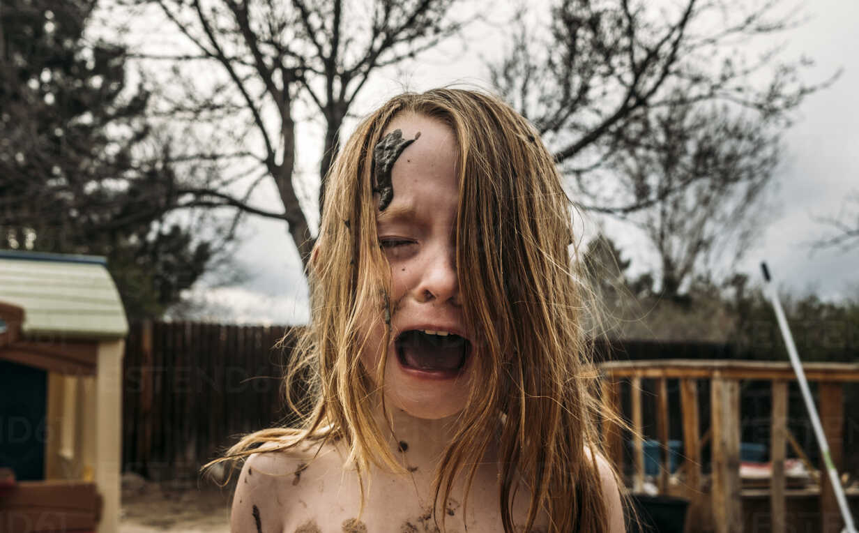 Close Up Of Girl Crying And Screaming With Mud On Face At Backyard