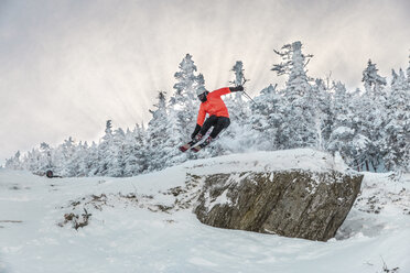 Mann macht Stunt in voller Länge beim Skifahren auf Schnee gegen Bäume im Winter - CAVF49697