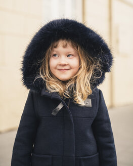 Smiling girl looking away while wearing fur coat outdoors - CAVF49699