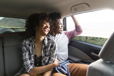 Glückliches Paar, das durch das Fenster schaut, während es im Auto unterwegs ist - CAVF49728