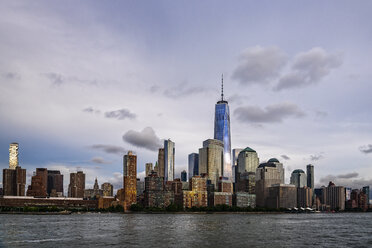 One World Trade Center amidst buildings in city by river against sky - CAVF49786