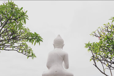 Low angle view of Buddha statue against clear sky - CAVF49809