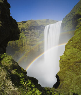 Blick auf den Regenbogen über dem Wasserfall Skogafoss bei klarem Himmel - CAVF49941