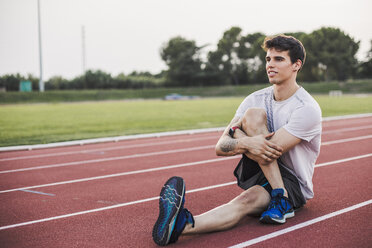 Athlete doing warm-up exercises on a tartan track - ACPF00360