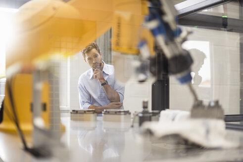 Businessman checking industrial robot in high tech company - DIGF05176