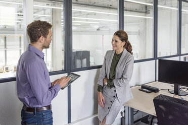 Businessman and woman having a meeting in company office - DIGF05201