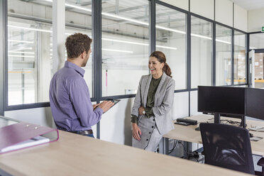 Businessman and woman having a meeting in company office - DIGF05202