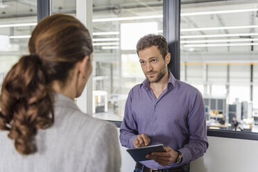 Businessman and woman having a meeting in company office - DIGF05203