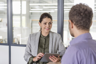 Businessman and woman having a meeting in company office - DIGF05204