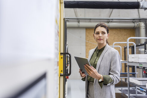 Businesswoman using digital tablet in high tech company - DIGF05212