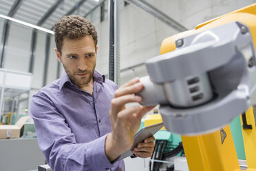 Technician adjusting industrial robot - DIGF05232