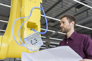 Businessman checking industrial robot in high tech company - DIGF05260