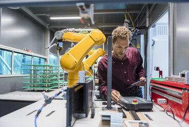 Businessman checking industrial robot in high tech company - DIGF05265