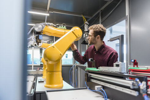 Businessman checking industrial robot in high tech company - DIGF05266
