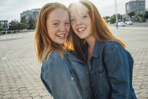 Smiling redheaded twins in the city, sunlight - VPIF00943