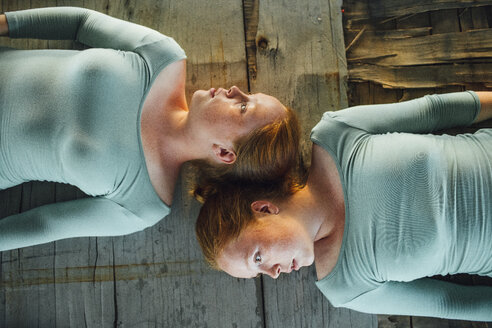 Redheaded twins lying on ground, looking away - VPIF00955