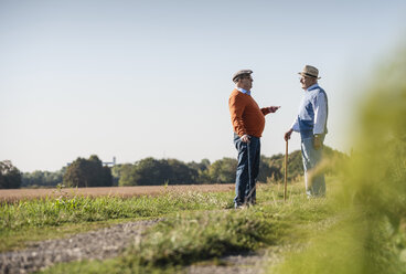 Zwei alte Freunde stehen auf den Feldern und reden über alte Zeiten - UUF15451
