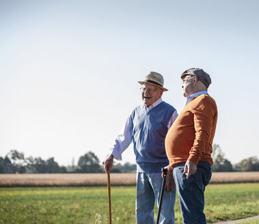 Two old friends standing in the fields, talking about old times - UUF15453