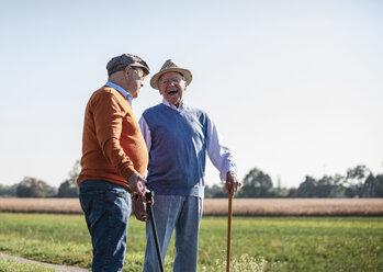 Zwei alte Freunde stehen auf den Feldern und reden über alte Zeiten - UUF15454