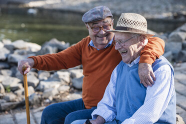 Zwei alte Freunde sitzen am Flussufer und haben Spaß - UUF15503