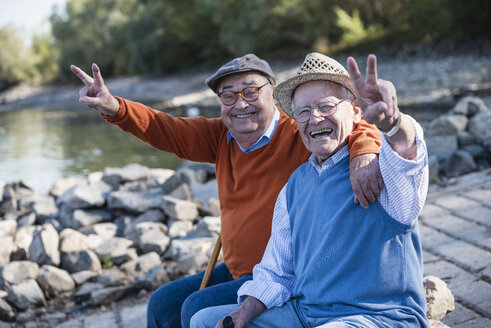 Zwei alte Freunde sitzen am Flussufer und haben Spaß - UUF15505