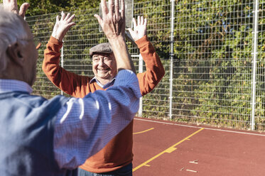 Zwei fitte Senioren, die sich auf einem Basketballfeld die Hände reichen - UUF15549